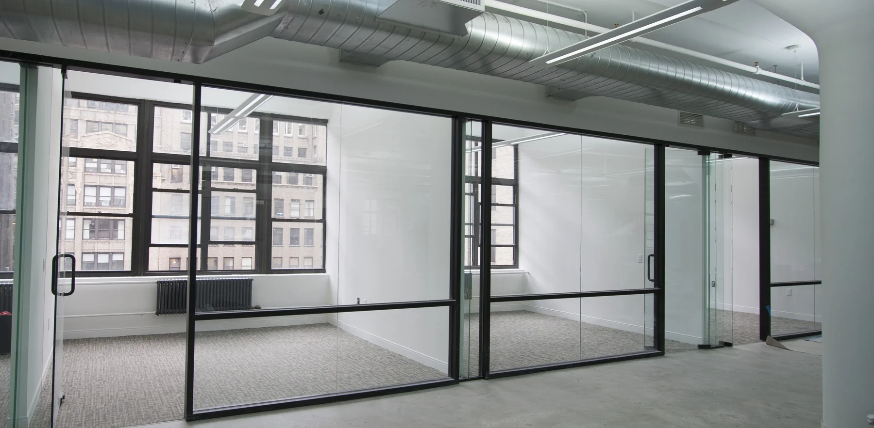 Glass-front private offices in a completed New York commercial interior